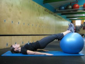 Personal Trainer, Tatum Rebel demonstrates hamstring curl with ball